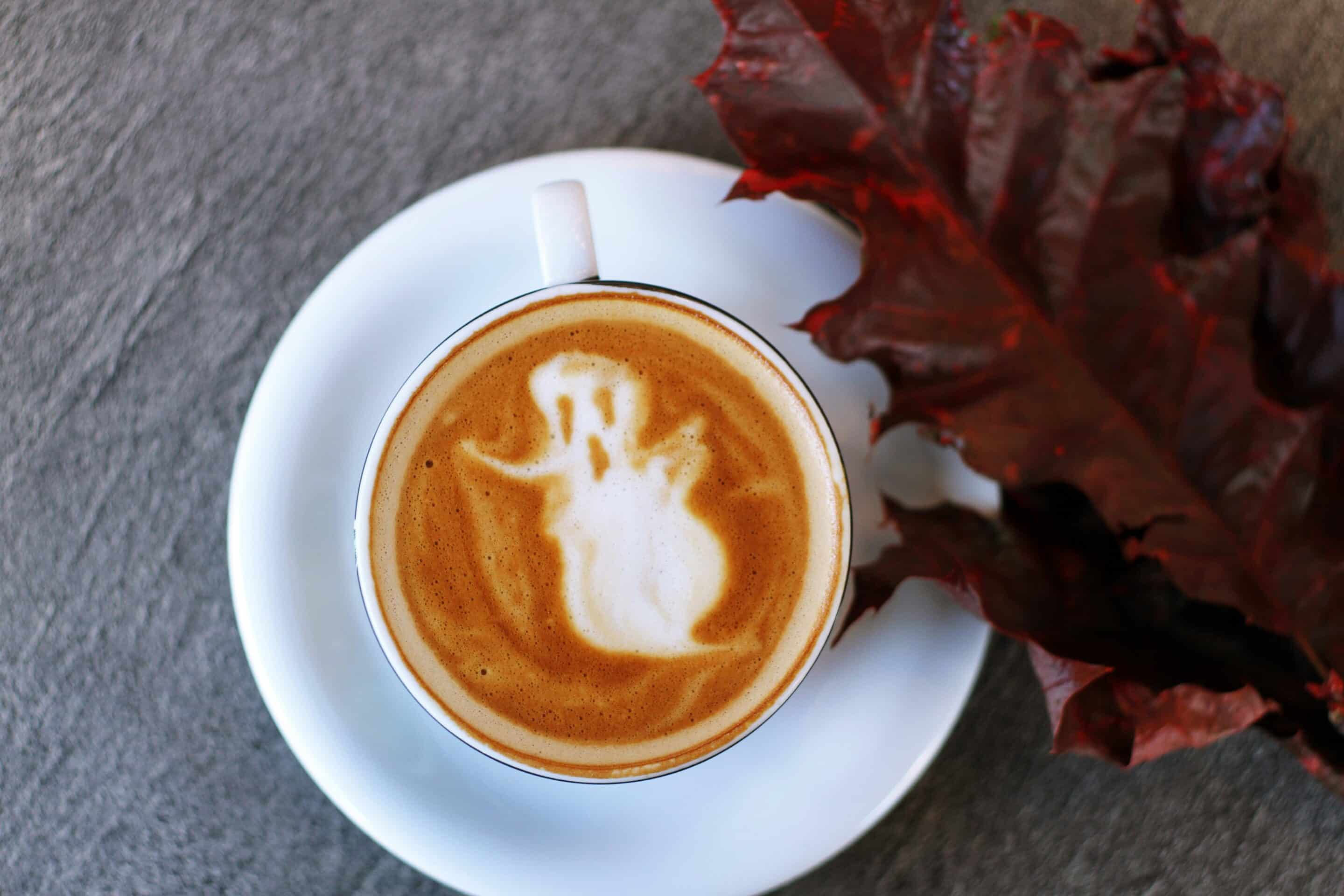 Latte art ghost with autumn leaf decoration